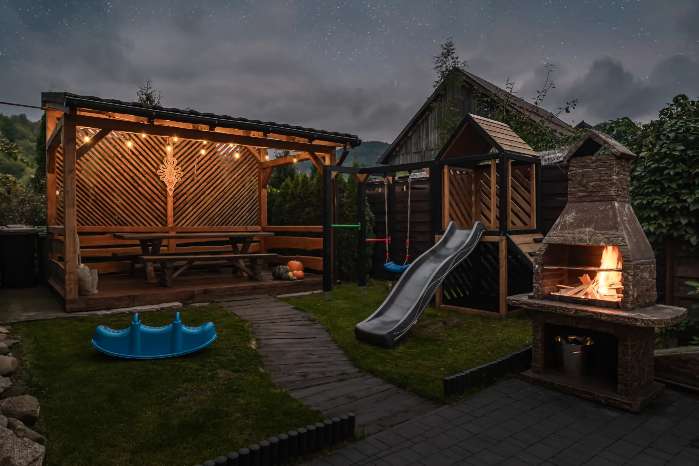 Shelter, playground and grill in the evening